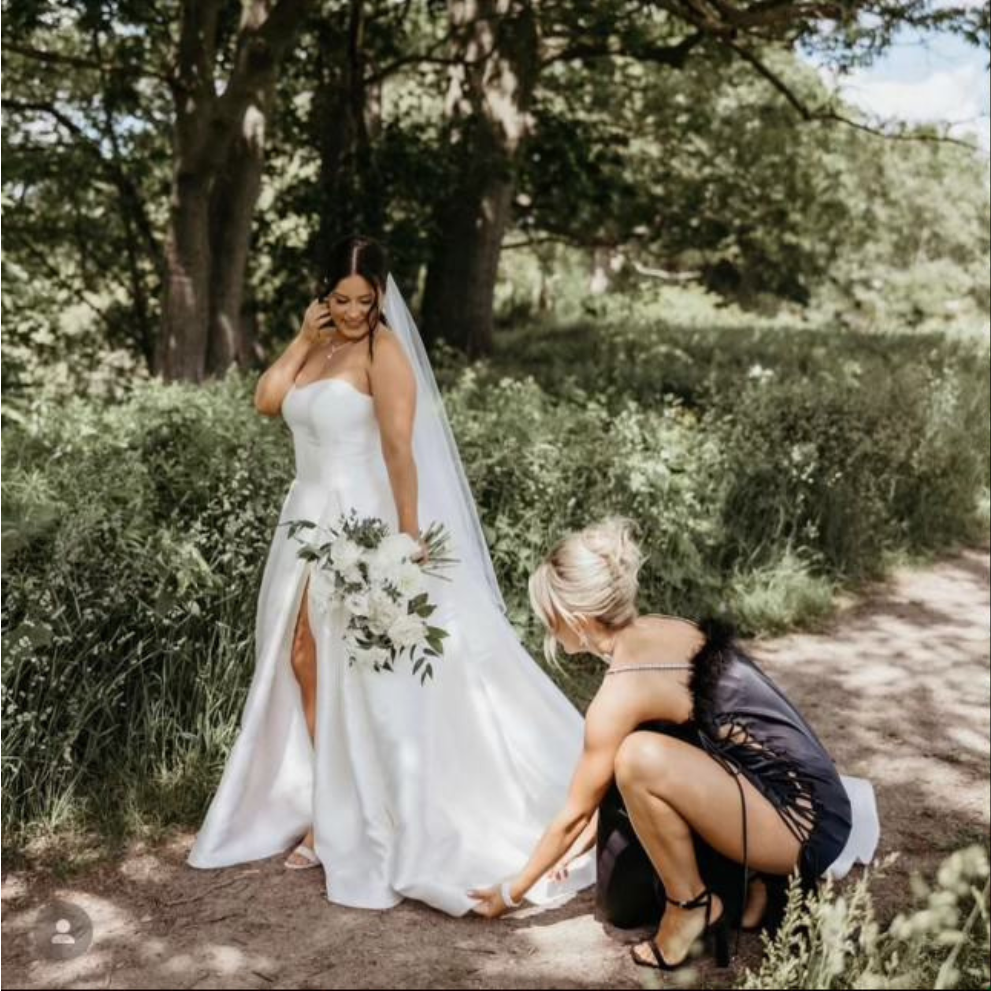 Bridesmaid fixing brides gown
